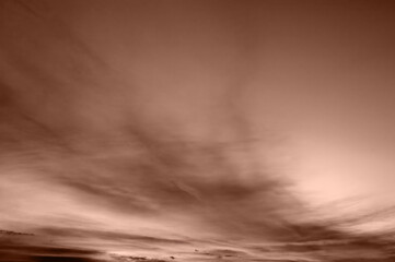 Subtle brown-tinted sky with soft, flowing clouds in motion, creating a serene view.