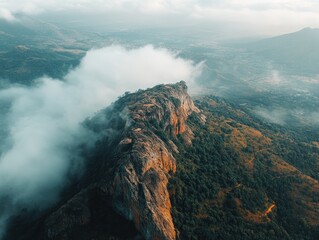 Aerial view of rocky mountain peak with a blanket of fog rolling in from the distance