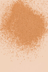 A sample of dry loose powder in a natural tone on a beige background. top view. A copy space. A layout to advertise the texture of the product.