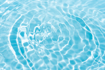 Blue water with ripples on the surface. Defocus blurred transparent blue colored clear calm water surface texture with splashes and bubbles. Water waves with shining pattern texture background.