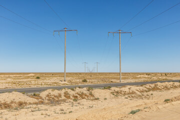 Power transmission lines stretching across the desert landscape of Karakalpakstan, Uzbekistan