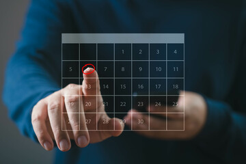 Person interacting with a futuristic digital calendar on a transparent screen, symbolizing modern technology and efficient time management.