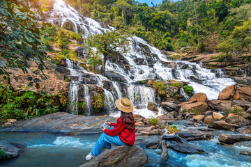 Tourist taking a photo and enjoy nature landscape at Mae ya waterfall, Chiang mai.