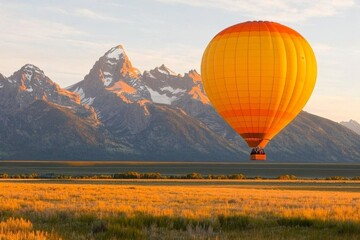 Fototapeta premium A hot air balloon floating over the Jackson Hole Valley, with the Tetons providing a stunning backdrop