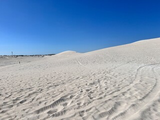 Lancelin, a coastal town in Western Australia, is famous for its white sand dunes, perfect for sandboarding, off-road adventures, pristine beaches, windsurfing, and a relaxed atmosphere.