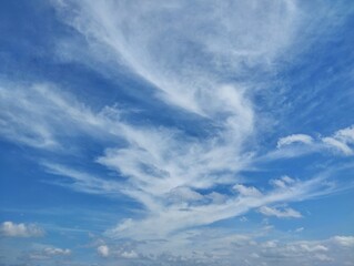 clear blue sky with a few clouds. The sky is very bright and the clouds are scattered throughout. Natural background texture 