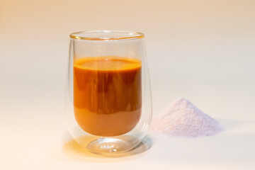 refreshing glass of Thai iced milk tea, served in a clear glass cup. The rich, vibrant orange color of the tea contrasts beautifully with the creamy milk at the bottom. A perfect blend