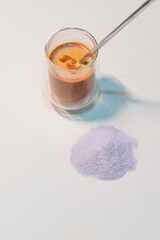 refreshing glass of Thai iced milk tea, served in a clear glass cup. The rich, vibrant orange color...