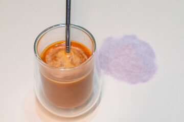 refreshing glass of Thai iced milk tea, served in a clear glass cup. The rich, vibrant orange color of the tea contrasts beautifully with the creamy milk at the bottom. A perfect blend