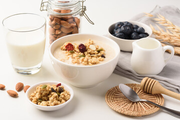 Oatmeal bowl with blueberries, granola, almonds and milk. Healthy breakfast concept.