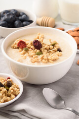 Oatmeal bowl with blueberries, granola, almonds and milk. Healthy breakfast concept.