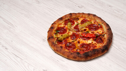 Baked pizza with sausage and pepper on a wooden textured gray table. Cooking. Restaurant advertising banner. Italian, spicy.