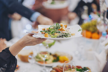 female hands taking food. People Dining in restaurant. Party dinner table, celebrating with friends or family served at home or in a restaurant, 