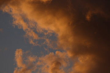 Vibrant sunset clouds illuminated by warm daylight against a deep blue sky
