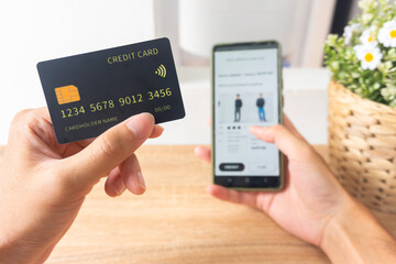 Pov first person holding black mockup credit card for online shop on smartphone at home