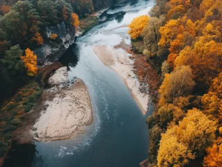 Foto op Plexiglas Aerial view of a meandering river surrounded by autumn foliage with sandy shores © uswatun