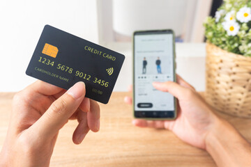 Pov first person holding black mockup credit card for online shop on smartphone at home