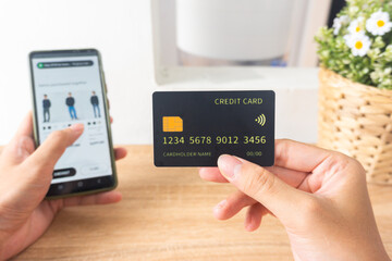 Pov first person holding black mockup credit card for online shop on smartphone at home