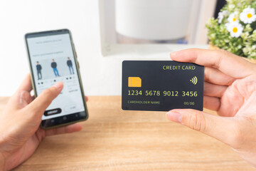 Pov first person holding black mockup credit card for online shop on smartphone at home