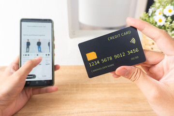 Pov first person holding black mockup credit card for online shop on smartphone at home