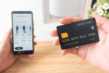 Pov first person holding black mockup credit card for online shop on smartphone at home