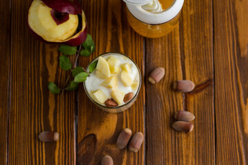 sweet homemade yogurt in a glass with apples, nuts and honey