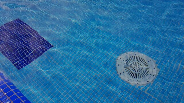 4k, video, Cleaning of the drain valve filter at the bottom of the swimming pool, movement of clear water, top view.