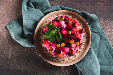 Close up of traditional beetroot salad with boiled vegetables and pickles on a plate top view
