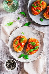 Italian sandwiches with tomatoes, basil and garlic on a plate on a table top and vertical view