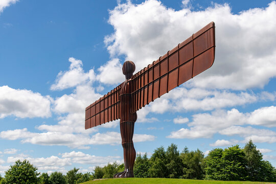 Gateshead, Tyne and Wear, UK-22 June 2024; The Angel of the North contemporary Corten weathering steel sculpture by Antony Gormley against a white clouded blue sky