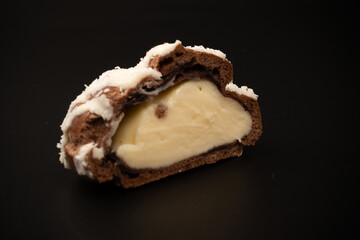 Profiteroles with coconut cream on a black background.