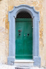 Fototapeta premium he aged entrance to a flat nestled within Maltas timeless old towns.