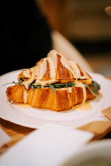 Freshly baked croissants served on a plate in a cozy coffee shop with a warm atmosphere and aromatic coffee nearby