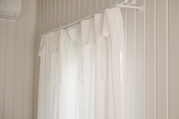 White curtains with ties in a stylish interior of a cozy home