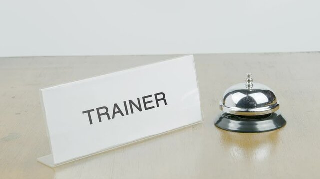 Trainer Office or Room with Hand Ringing The Bell on Desk or Table Multiple Times