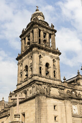 Iglesia ubicada en la ciudad de México en la que se puede ver el campanario y un reloj en la fachada de la iglesia y un monumento en forma de cruz en la parte de abajo