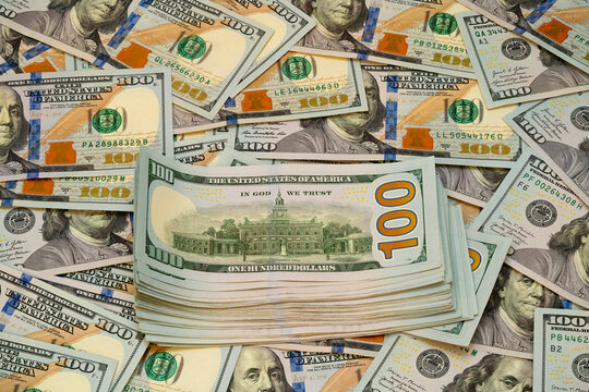 Stacks of hundred dollar bills arranged on a flat surface