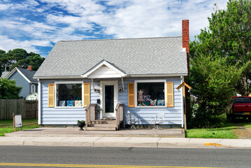 small nice house with a well-groomed lawn. Blue sky on a sunny day.