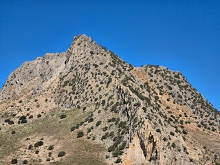 Barren mountain against blue sky - sharp horizon of rock