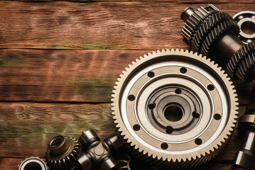 Car spare parts on an old wooden workbench top view background in a garage of auto service.