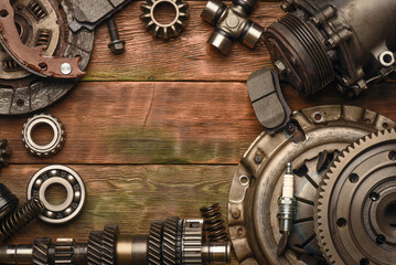 Car spare parts on an old wooden workbench top view background in a garage of auto service.