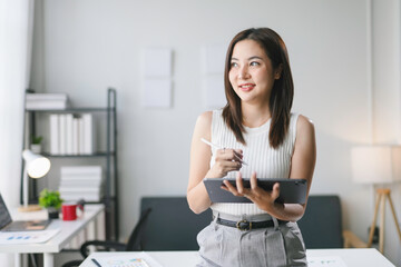 Asian businesswoman working with digital tablet and stylus in modern office, technology and...