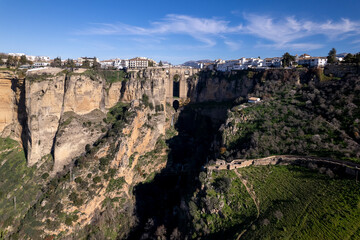 Ronda Puente Nuevo bridge over El Tajo gorge and Guadalevin river with lookout point in the foreground and rising rock cliffs supporting the village above
