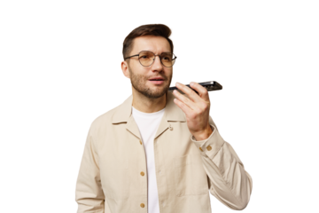 Man communicates using a voice recorder while standing in a bright setting, focused and attentive