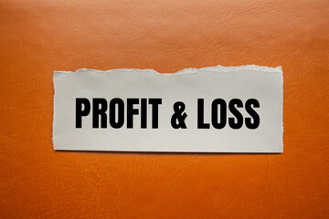 Profit and loss message written on ripped torn paper piece with brown background. Conceptual profit and loss symbol. Copy space.