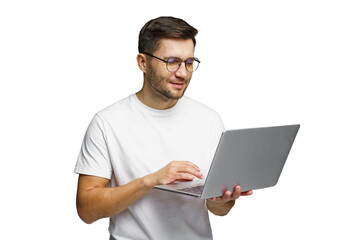 Man using laptop at home while wearing glasses and a simple t-shirt with a smile on his face