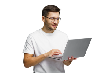 Man using laptop at home while wearing glasses and a simple t-shirt with a smile on his face