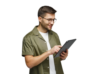 Young man using a tablet while smiling and standing against a plain background indoors