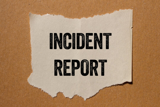 Incident report message written on ripped torn paper piece on brown background. Conceptual incident report symbol. Copy space.