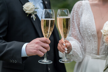 Wedding glasses in hands bride and groom